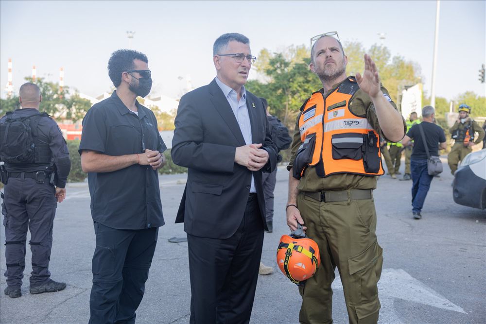 אנשי ציבור וקצין בשיחה בזירת אירוע